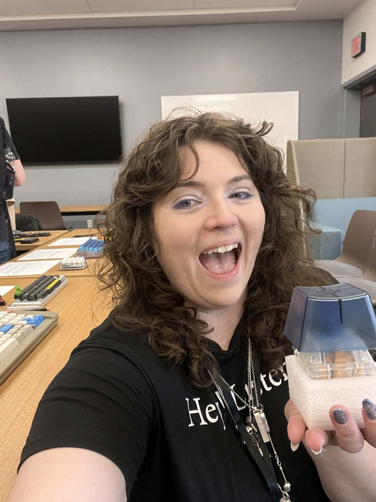 A woman taking a selfie of herself holding a NovelKeys big blue clicky switch