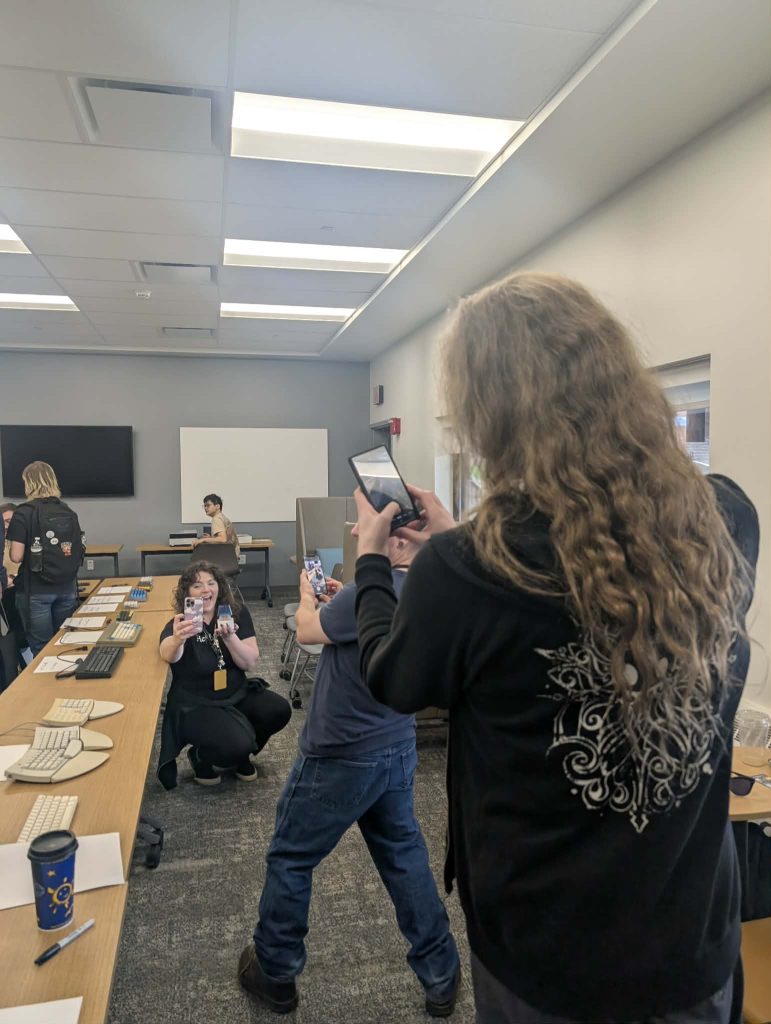A picture of a person taking a picture of a man taking a picture of a woman taking a selfie of herself holding a NovelKeys big blue clicky switch